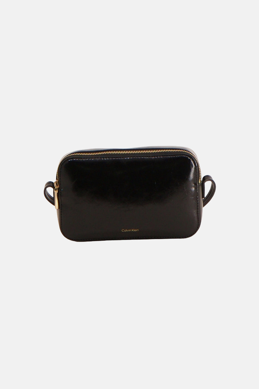 Sac à bandoulière noir Calvin Klein en matière brillante avec fermeture éclair dorée et un logo doré sur le devant.