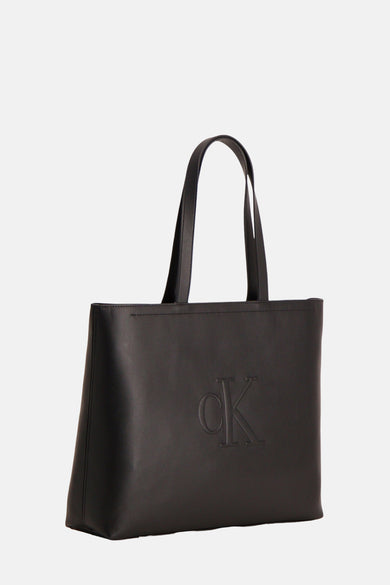 Sac à main noir de Calvin Klein, avec un subtil logo CK en relief sur l'avant.