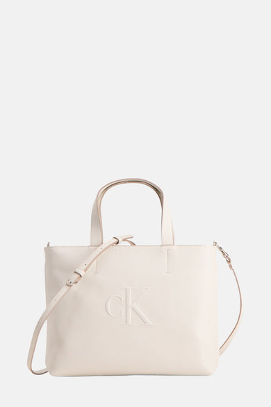 Crèmekleurige Calvin Klein tas met logo en schouderband.
