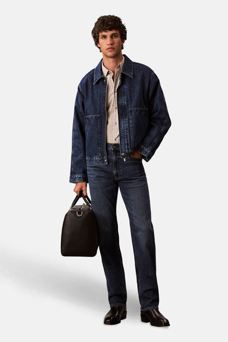 Jean droit bleu marine de Calvin Klein, associé à un blau denim et une sac en cuir.