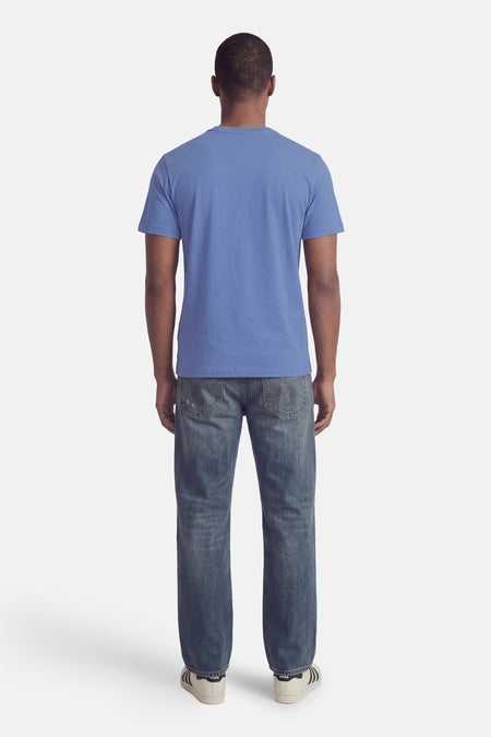 Blauwe korte mouw T-shirt van Calvin Klein, achterzijde, eenvoudig design, gedragen met jeans en witte sneakers