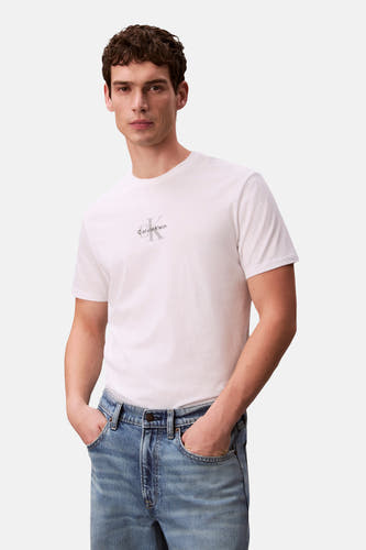 T-shirt blanc à manches courtes de Calvin Klein, porté sous un blouson en denim et des jeans coordonnés.
