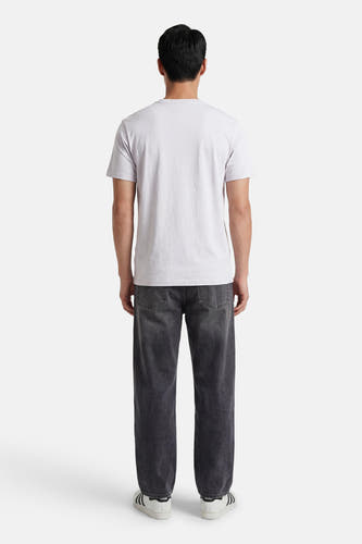 Grijze korte mouw T-shirt van Calvin Klein, achterzijde, eenvoudig design, gestreept textuur, model draagt donkere jeans en witte sneakers