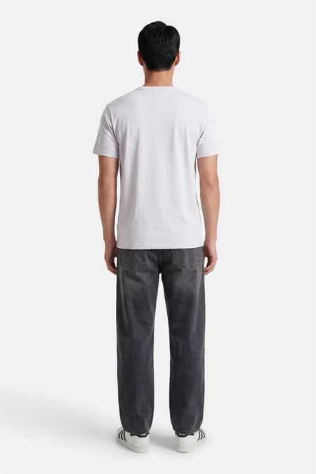Grijze korte mouw T-shirt van Calvin Klein, achterzijde, eenvoudig design, gestreept textuur, model draagt donkere jeans en witte sneakers