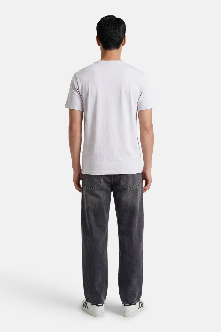 Grijze korte mouw T-shirt van Calvin Klein, achterzijde, eenvoudig design, gestreept textuur, model draagt donkere jeans en witte sneakers
