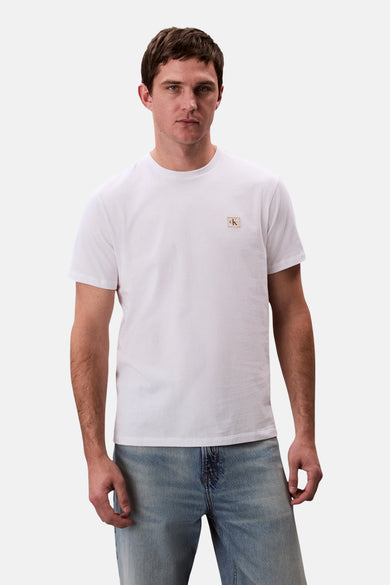 T-shirt blanc à manches courtes de Calvin Klein, porté avec un jean.