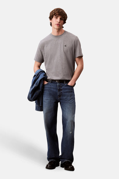 T-shirt gris à manches courtes de Calvin Klein, avec un logo subtil sur la poitrine et une apparence décontractée.