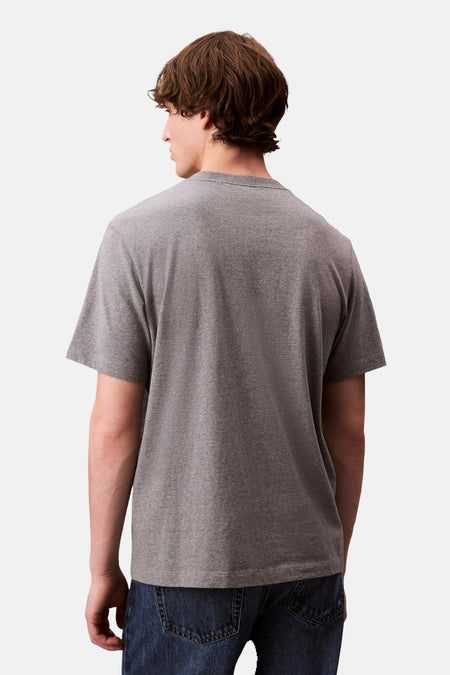 T-shirt gris à manches courtes de Calvin Klein, vu par derrière, associé à des jeans foncés.