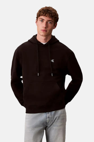 Sweat à capuche noir Calvin Klein, avec petit logo blanc sur la poitrine, vue de face, le modèle porte un jean clair