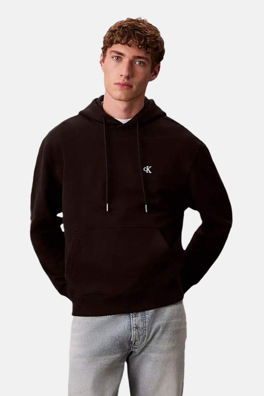 Sweat à capuche noir Calvin Klein, avec petit logo blanc sur la poitrine, vue de face, le modèle porte un jean clair