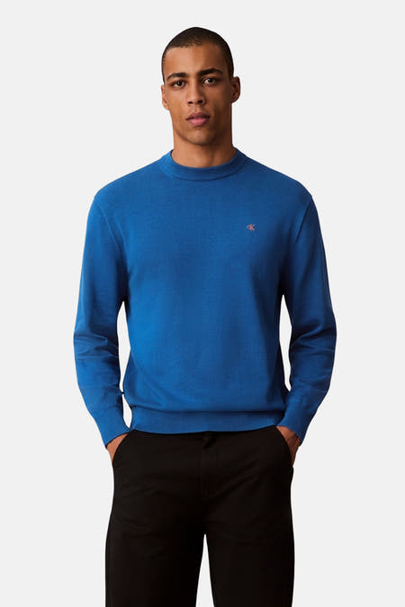 T-shirt bleu avec col rond de Calvin Klein, porté avec un pantalon noir.