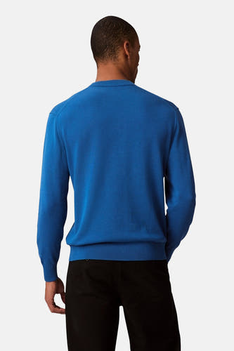 Pull-over bleu avec col rond de Calvin Klein, vu de derrière, associé à un pantalon noir.