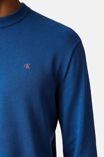 Gilet bleu avec col rond de Calvin Klein, avec un petit logo orange sur la poitrine.