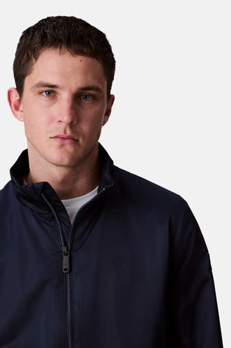 Veste de pluie bleue Calvin Klein, avec fermeture éclair et un petit logo CK sur la poitrine.