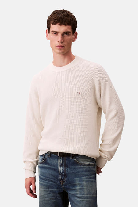 Sweat-shirt beige avec col rond de Calvin Klein, vu de l'arrière, avec une texture tissée et des jeans bleus.