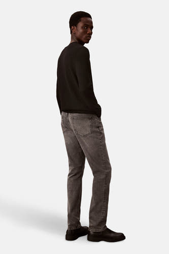 Jean slim en denim gris moyen de Calvin Klein, vu de l'arrière combiné avec un un-shirt et et noir des noires.