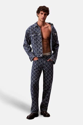 Manteau de denim bleu court de Calvin Klein, avec un motif all-over et porté ouvert sur le corps.