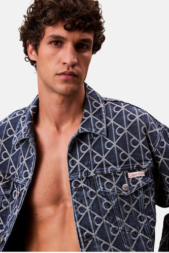 Short denim jacket in mid blue from Calvin Klein, with a pattern of logos.