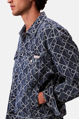 Manteau de denim bleu nuit court Calvin Klein, avec un motif géométrique et une poche visible.
