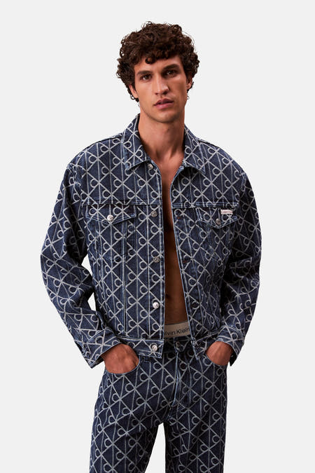 Manteau de denim bleu court de Calvin Klein, avec un motif graphique et des détails argentés.
