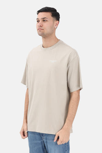 Beige T-shirt met korte mouwen van Calvin Klein, met een klein logo op de borst en gedragen met een blauwe jeans.