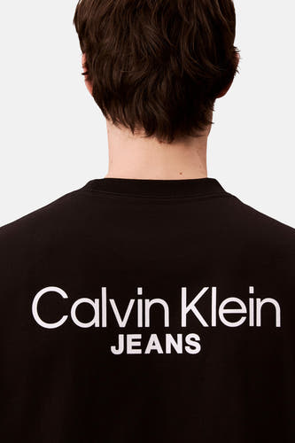 T-shirt noir à manches courtes de Calvin Klein Jeans, avec imprimé logo blanc sur le dos.