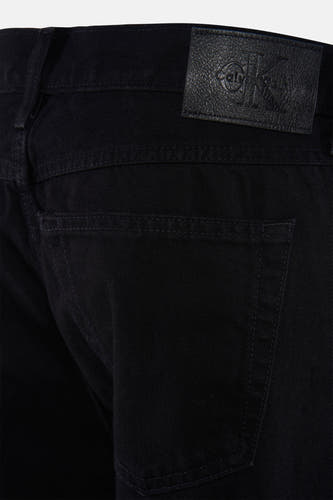 Jean droit noir de Calvin Klein, avec patch logo en cuir sur la ceinture et la poche arrière.
