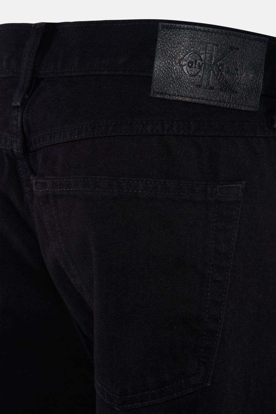 Jean droit noir de Calvin Klein, avec patch logo en cuir sur la ceinture et la poche arrière.