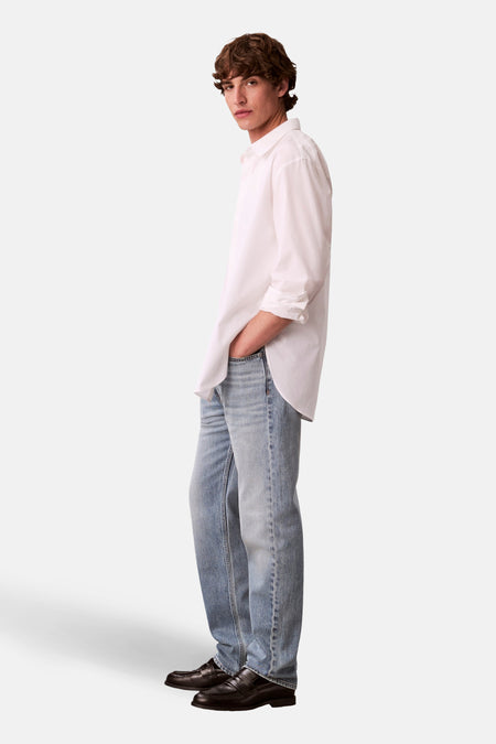 Jean bleu clair droit de Calvin Klein, avec une coupe décontractée et des mocassins en cuir noir.