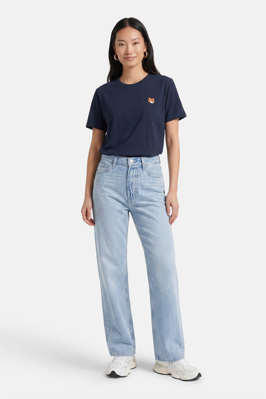 Lichtblauwe straight jeans van Calvin Klein, met hoge taille en lichte was, gedragen met donkerblauw T-shirt en witte sneakers, front view.