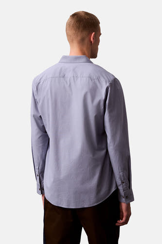 Chemise bleue à manches longues de Calvin Klein, vue de l'arrière, avec col boutonné et tissu lisse.