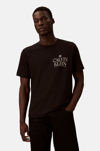 T-shirt noir à manches courtes de Calvin Klein, avec une impression dorée de fleurs en forme de losange sur le dos.