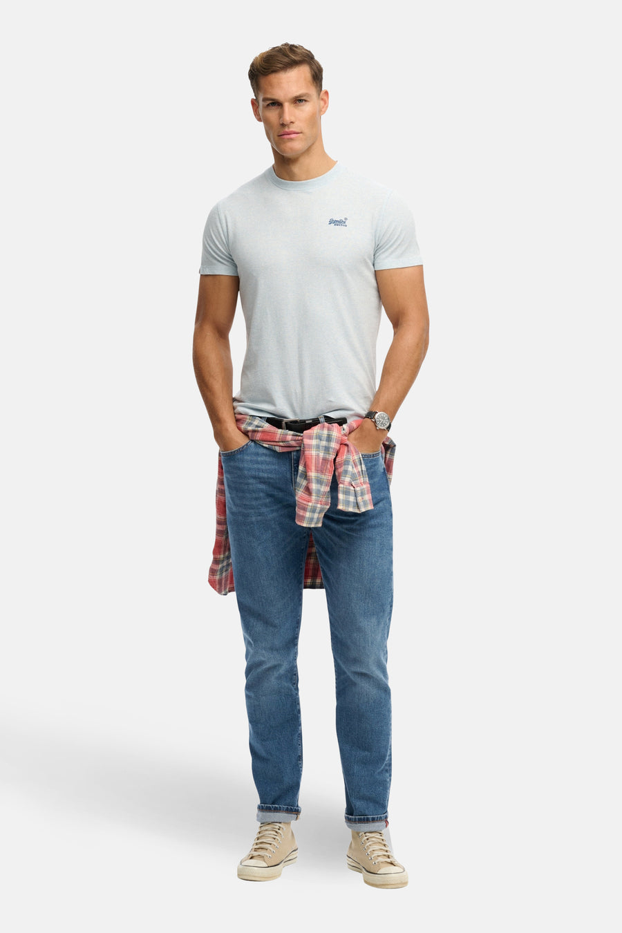 Lichtblauwe korte mouwen T-shirt van SUPERDRY met klein logo op borst, gedragen met jeans en geruit overhemd in taille, front view
