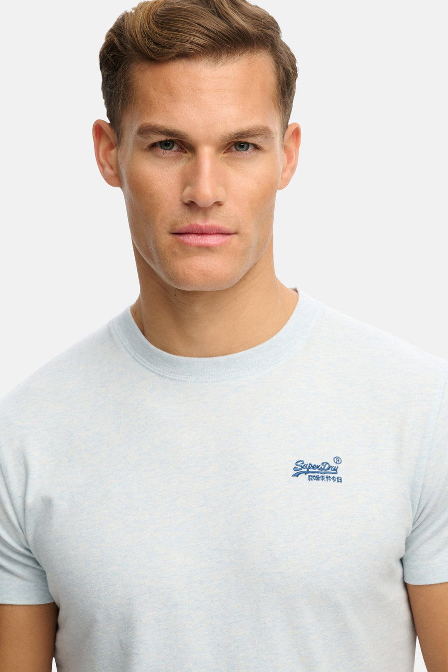 Blauwe korte mouw t-shirt van SUPERDRY met klein logo op borst, lichte melange stof, lifestyle shot van model