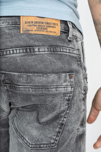 Short en denim gris de Petrol Industries, avec un lavage vintage et une étiquette en cuir marron sur l'arrière.