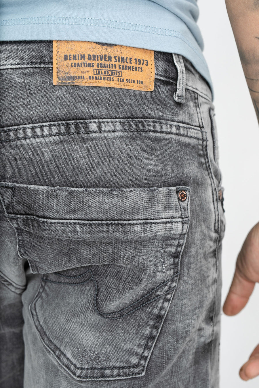 Short en denim gris de Petrol Industries, avec un lavage vintage et une étiquette en cuir marron sur l'arrière.