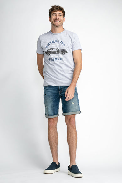 Jean denim court de Petrol Industries® avec des zones d'usure et des jambes repliées.
