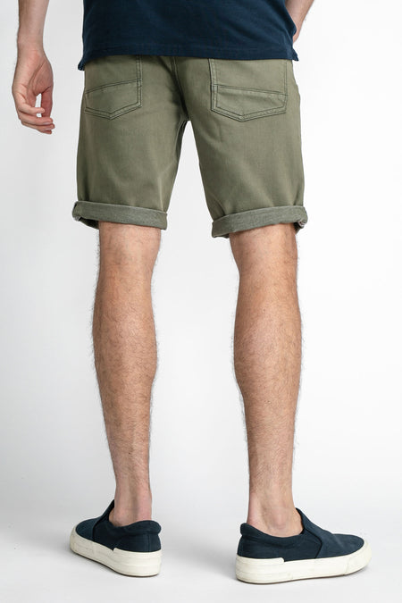 Short en jean vert avec jambes retroussées de Petrol Industries®, dos avec deux poches, look décontracté, modèle portant un t-shirt bleu foncé et des baskets