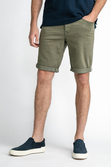 Short en jean vert avec ourlets roulés de Petrol Industries®, porté avec un t-shirt bleu foncé et des slip-ons, vue de face