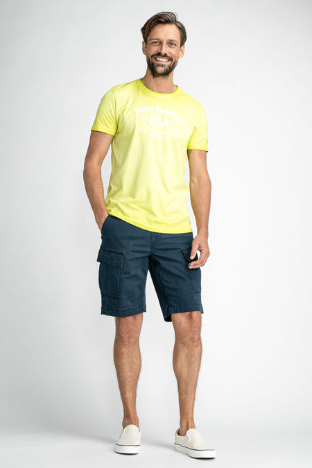 Short cargo bleu de Petrol Industries® avec grandes poches, porté avec un t-shirt jaune et des baskets blanches, vue de face