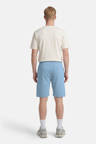 Short bleu de Petrol Industries, vu de dos, avec une seule poche arrière et combiné avec un t-shirt de couleur crème.