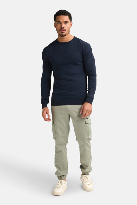 T-shirt bleu avec col rond de Petrol Industries, porté avec un pantalon cargo kaki et des baskets crème.