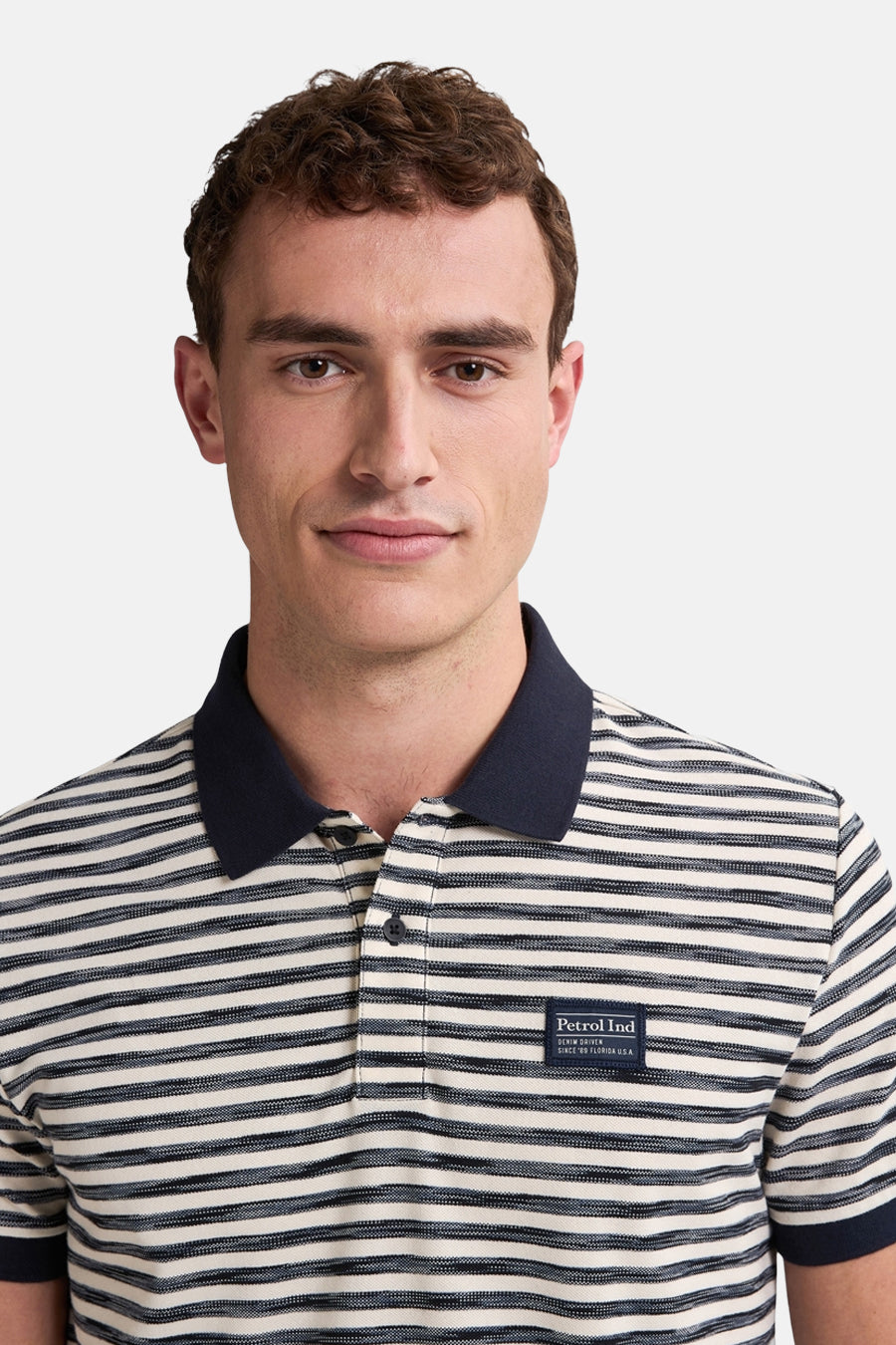 Man met gestreepte polo, donkerblauwe kraag.