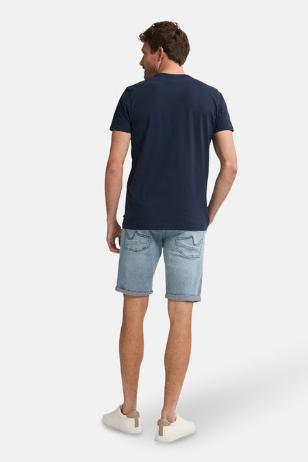Lichtblauwe denim short van Petrol Industries, gezien van achteren, met beige schoenen.
