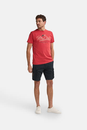 Shorts noirs de Petrol Industries avec poches sur les côtés, associés à un t-shirt rouge et des baskets blanches.