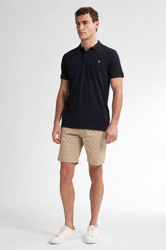 Beige court de Petrol Industries avec un motif subtil de plis, combiné à un t-shirt noir et des baskets blanches.