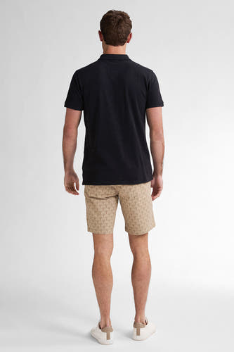 Beige court de Petrol Industries avec un motif graphique, combiné à un t-shirt noir et des baskets blanches.