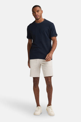Beige court de Petrol Industries®, associé à un T-shirt bleu marine et des baskets blanches.