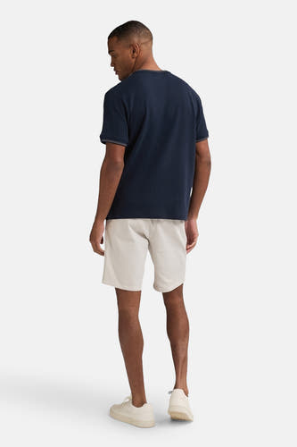 Beige court de Petrol Industries®, complet avec un T-shirt bleu marine et des baskets crème.