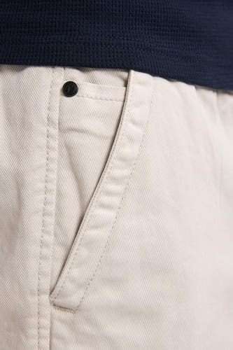 Pantalon court beige de Petrol Industries® avec une poche et un chemisier bleu marine.